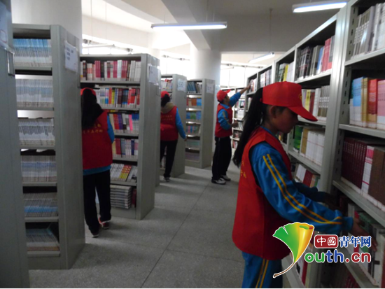 南昌大学研支团成员带领图书馆志愿服务队开展图书整理和清洁活动。叶建飞 供图